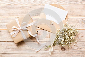 Wedding mockup with white paper list and flowers gypsophila on colored table top view flat lay. Blank greeting cards and
