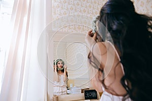 Wedding morning. The bride looks in the mirror