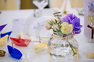 Wedding nautical table arrangement with flower bouquet and origami boats