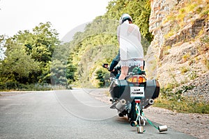 Wedding, newlyweds. A man and a woman in wedding dresses and motorcycle helmets, riding a motorcycle on the road. The woman stands