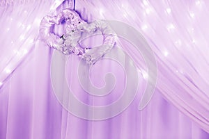 Wedding ornament with two hearts and curtain and lights.