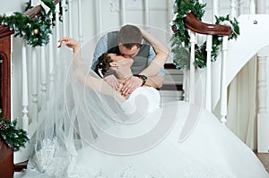 Wedding pair, kiss on stairs. Veil