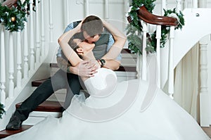 Wedding pair, kiss on stairs. Veil. Indoor