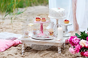 Wedding or party candy bar, decorated dessert table in pink color with cakes. Shabby chic style