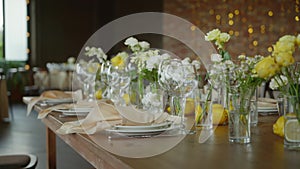 a wedding party table decorated with fresh flowers in yellow and white