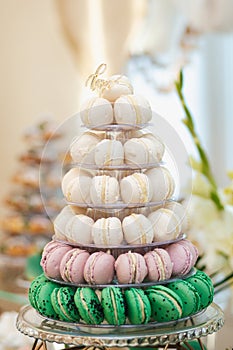 Wedding pastries on a mirror tray. Candy bar. Buffet with macaroons delicacies at the wedding. Sweet candy bar on table