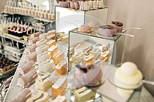Wedding pastries on a mirror tray. Sweet candy bar on table. Beautiful bright buffet with many sweet snacks a candy bar