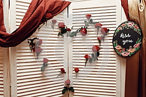 Wedding photo booth zone. rustic wooden wall with flowers, red r