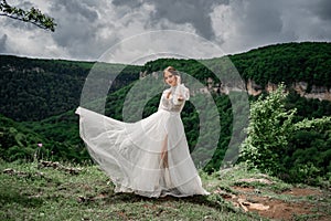 wedding photo shoot in the mountains. the bride in flutters skirt on the meadow.