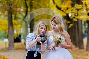 Wedding photographer discussing with the bride recently taken photos