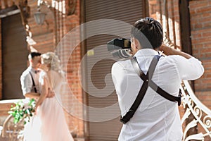 Wedding photographer takes pictures of bride and groom