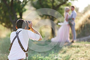 Wedding photographer takes pictures of bride and groom