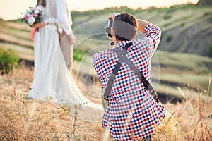 Wedding photographer takes pictures of bride and groom