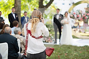 Wedding photographer takes pictures of the bride and groom during the ceremony