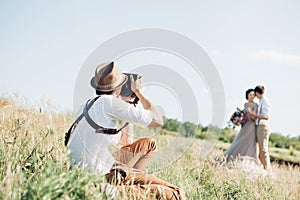 Wedding photographer takes pictures of bride and groom in nature, fine art photo