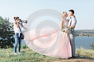 Wedding photographer takes pictures of bride and groom