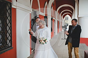 Wedding photographer taking pictures of the bride and groom in a gallery