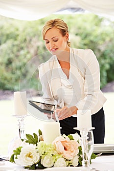 Wedding Planner Checking Table Decorations In Marquee