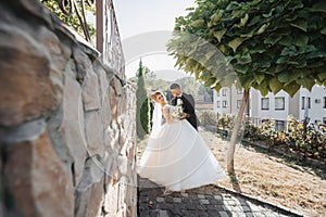 Wedding portrait. The groom in a black suit and the blonde bride in a white dress