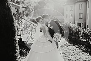 Wedding portrait. The groom in a black suit and the blonde bride in a white dress