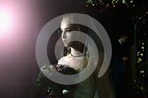 Wedding portrait. Portrait of a girl in a wedding dress with a veil on a dark background.