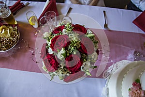 A wedding posy with red roses and white flowers