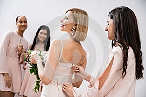 wedding preparations, bridesmaid zipping wedding dress