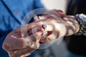 Wedding proposal, a man putting a ring on a woman`s finger | Couple in love and getting married