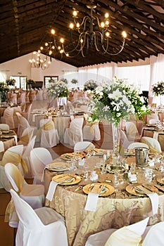 Wedding reception hall with laid tables photo