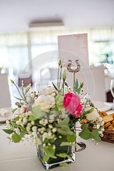 Wedding reception photo. Glasses and flowers on tables.