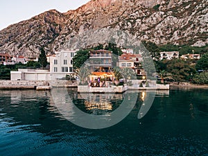 Wedding Reception Table Setting, dinner by the sea aerial. Guests are sitting at a table by the sea, amid a hotel