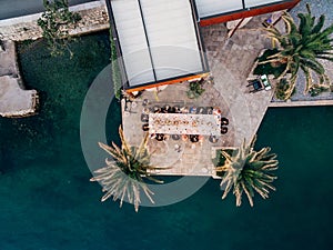 Wedding Reception Table Setting, dinner by the sea aerial top view. Guests at the wedding banquet sit at the table, the