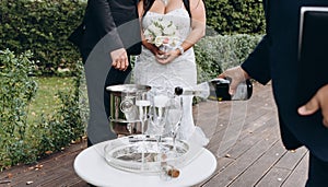 Wedding registrar fill glasses with champagne for happy bridal couple.