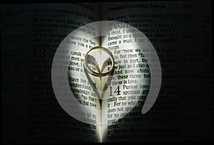 Wedding ring in Bible surrounded by heart light
