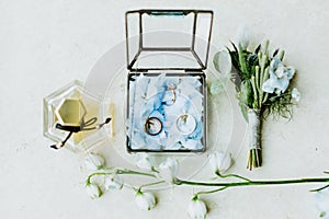 Wedding ring and flowers with perfume lay flat