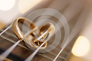 Wedding ring in a heart shape on ukulele guitar strings