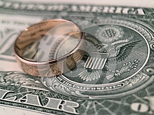 The wedding ring lies on a dollar bill. Gold ring on american dollars. Concept: marriage of convenience