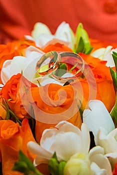 Wedding ring. Two gold vintage rings and a bride`s bouquet of orange roses and white flowers