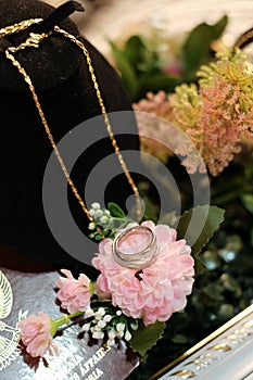 A Gold Wedding ring and Neckalace on terarium Box photo