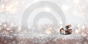 Wedding rings on an abstract silver glittering bokeh background