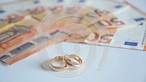 Wedding rings and banknotes focusing