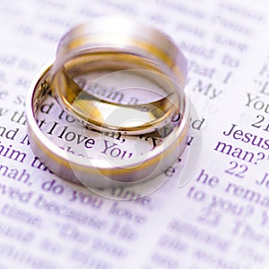 Wedding rings on a Bible with I Love You message