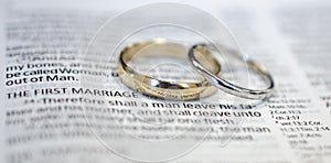 Wedding rings on Bible scripture photo