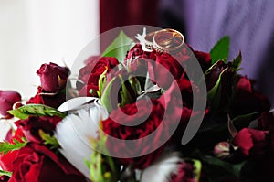 wedding rings on a bouquet of red roses