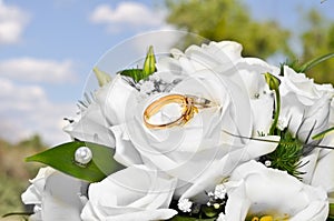 Wedding rings on a bouquet of white flowers