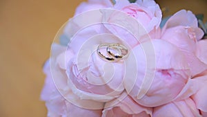 Wedding rings on a bouquet of white flowers. wedding rings and bouquet of dark blue flower. Close up. Wedding