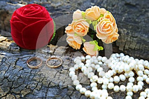 Wedding rings, boutonniere and a string of pearls