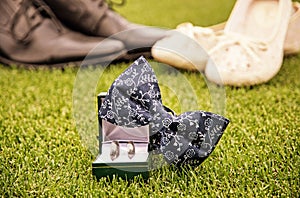 Wedding rings, bow tie and women`s and men`s shoes, yellow filte