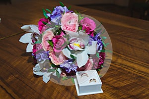 Wedding rings of the bride and groom on a Beautiful wedding bouquet. White ring box