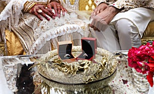 Wedding rings for the bride and the groom in-front of them. Newly wed couple with their wedding rings in-front of them.